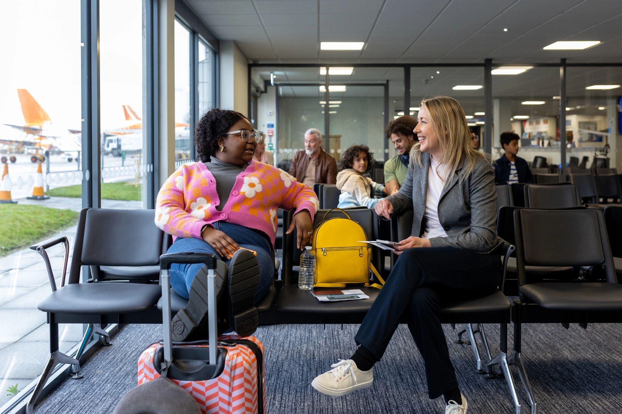 Travelers discussing plans in an airport departure lounge